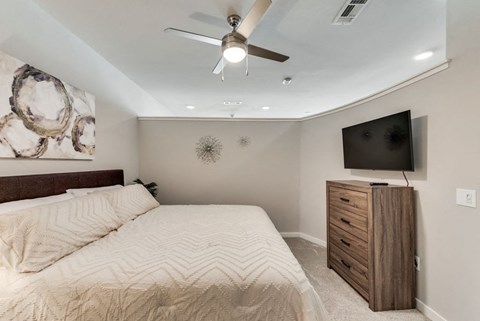 a bedroom with a large bed and a ceiling fan