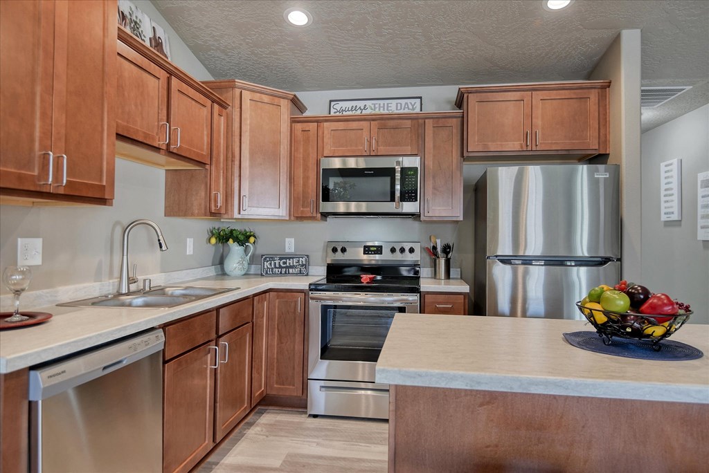 A kitchen with wooden cabinets and stainless steel appliances.