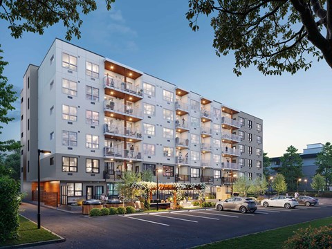 A modern apartment building with cars parked in front.