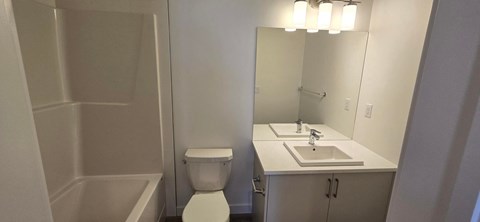 A white bathroom with a toilet, sink, and tub.