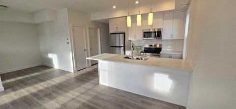 A modern kitchen with a white countertop and a microwave above it.