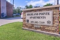 a sign for highland point apartments in front of a brick building