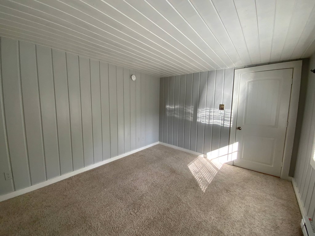 A room with a carpeted floor and a door.