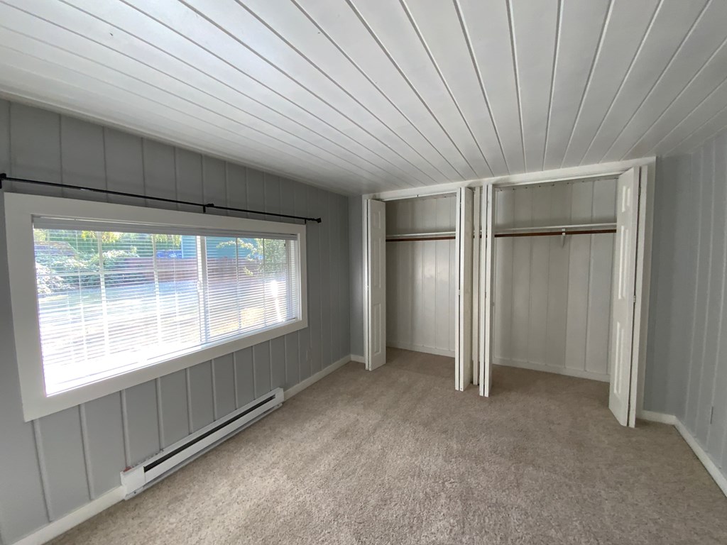 A room with a window and a car parked outside.