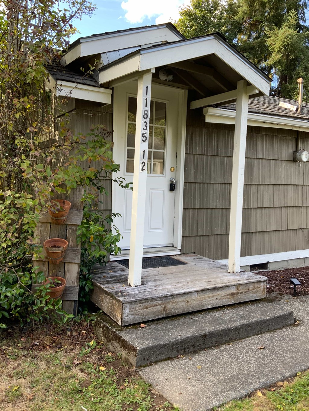 A small house with a white door and a porch.