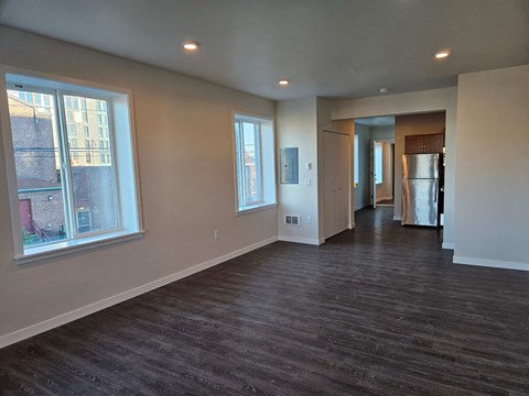 A spacious room with a window and a door leading to another room.