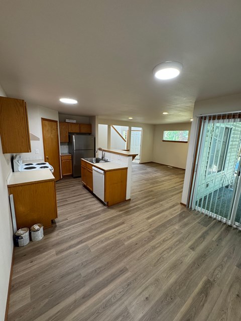 A kitchen with wooden cabinets and a refrigerator.