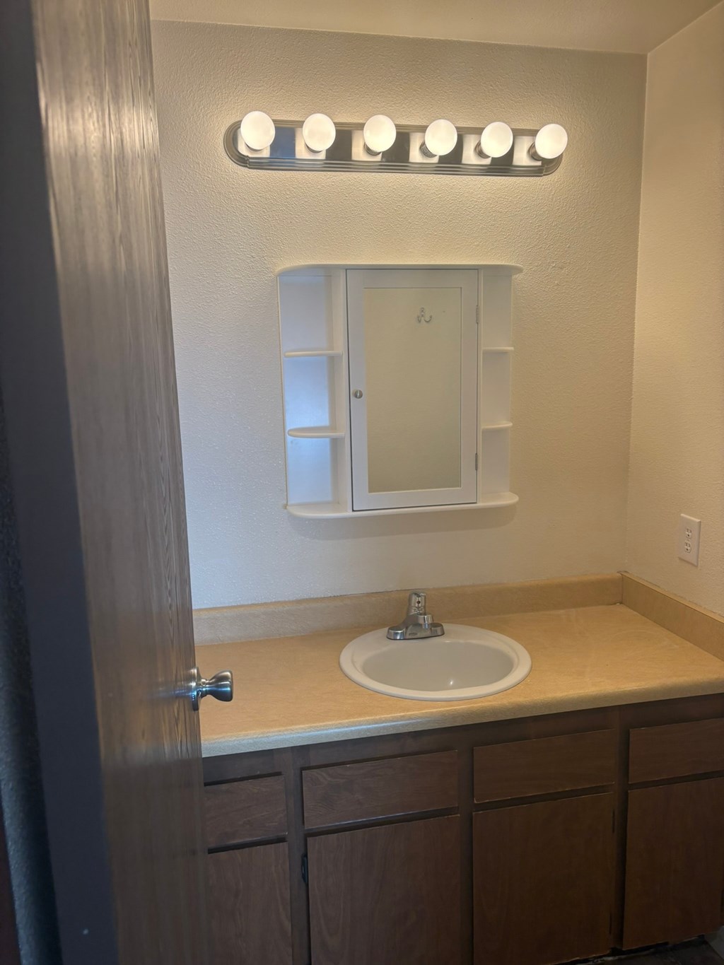 A bathroom with a sink and mirror.
