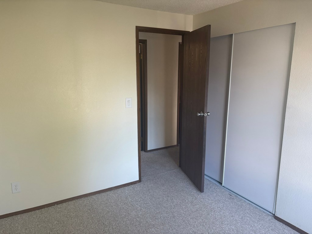 A room with a carpeted floor and a white wall.