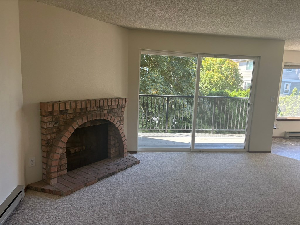 A room with a fireplace and sliding glass doors.