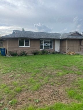 a brown house with a yard in front of it