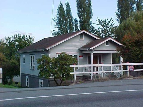 A house with a brown roof and a white fence.