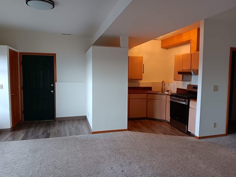A kitchen area with a black door and a white wall.