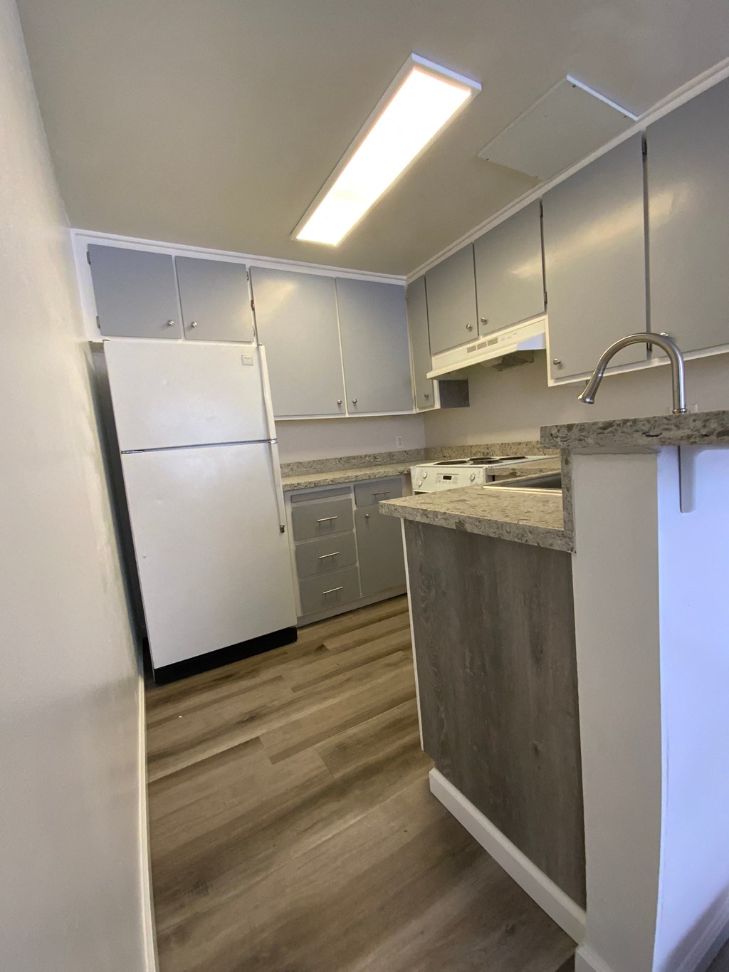 an empty kitchen with white cabinets and stainless steel appliances