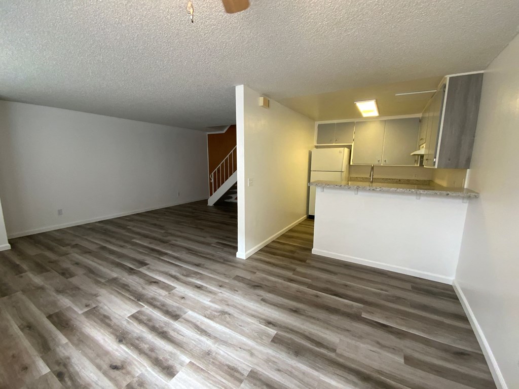 an open living room and kitchen with wood flooring
