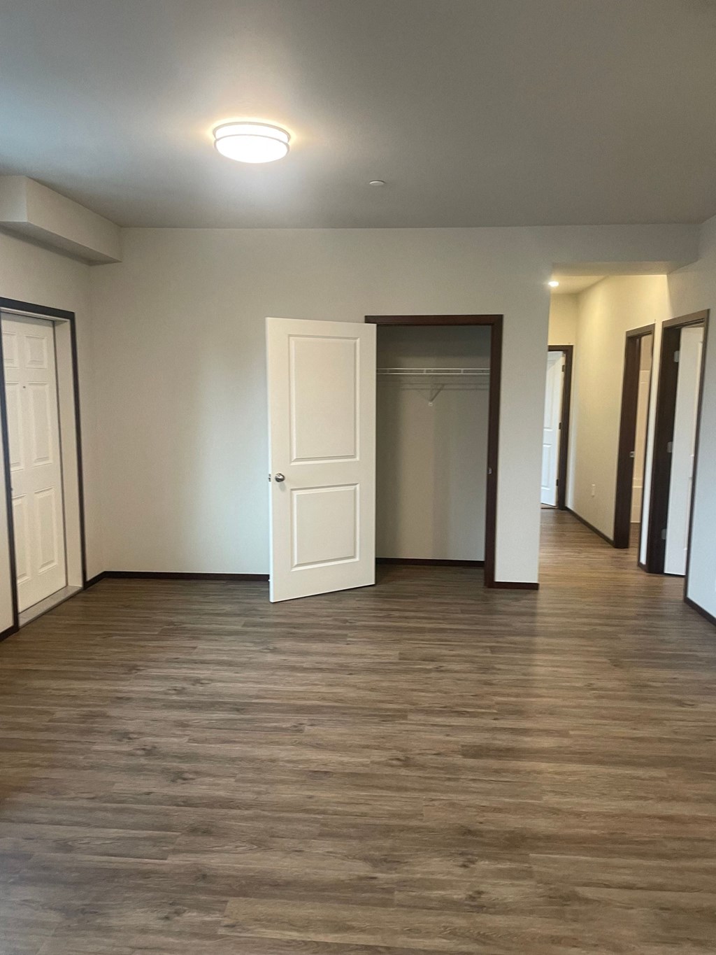 an empty living room with white walls and a wooden floor