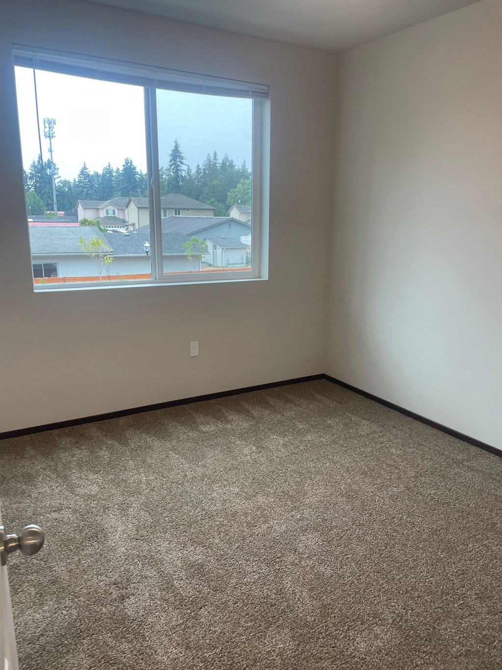 a room with a large window and a carpeted floor