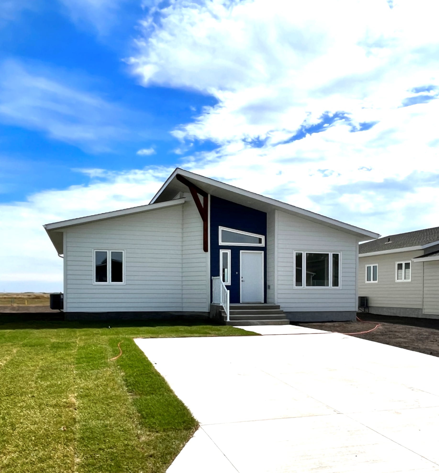 A small white house with a blue door and windows.