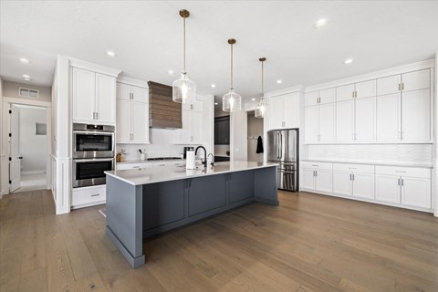 a large kitchen with white cabinets and a large island