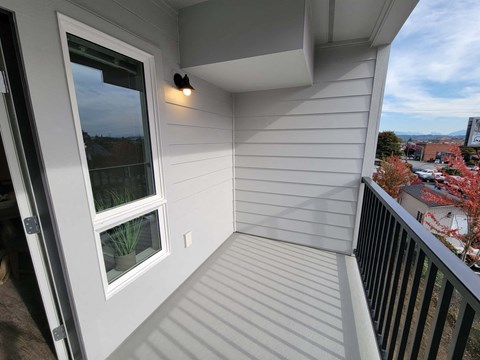 A balcony with a window and a view of the city.