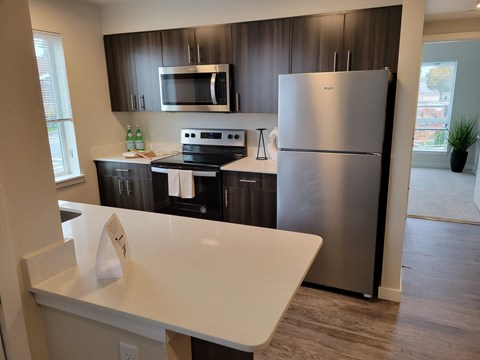A modern kitchen with a stainless steel refrigerator and microwave.