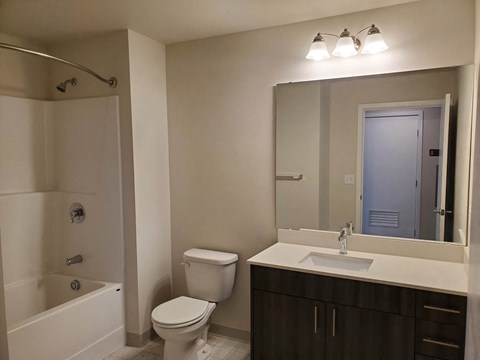 A bathroom with a white toilet, sink, and bathtub.