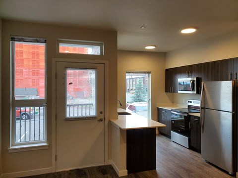 A kitchen with a refrigerator, stove, and microwave.