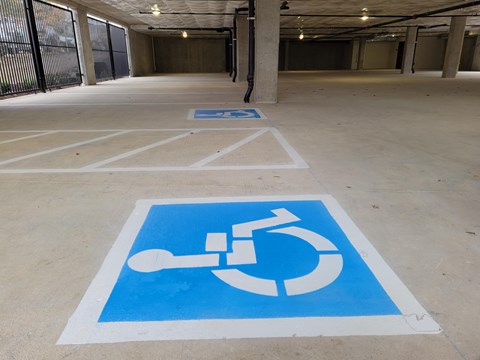 A parking space with a wheelchair symbol painted on the ground.