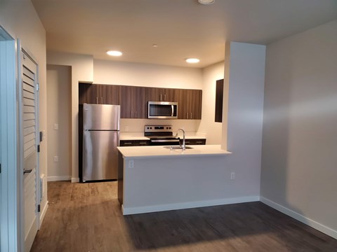 A kitchen with a refrigerator, microwave, and oven.