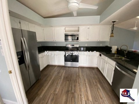 A kitchen with a black stove top oven and white cabinets.