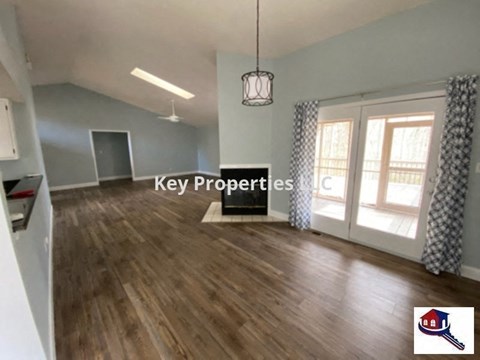 A room with wooden floors and a hanging light fixture.