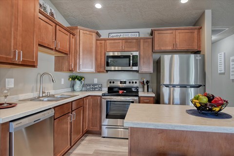 A kitchen with wooden cabinets and stainless steel appliances.