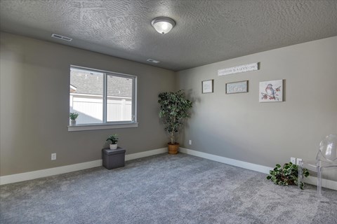 A room with a grey carpet and a white chair.
