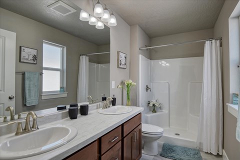 A bathroom with a white sink and a white toilet.