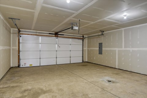 A garage with a white door and a concrete floor.