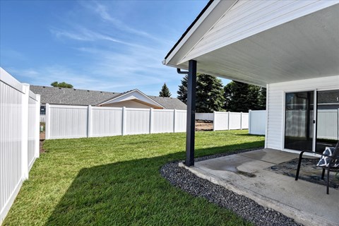 A white house with a black pole in front of it.