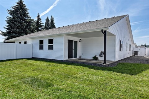 A white house with a grey roof and a black door.
