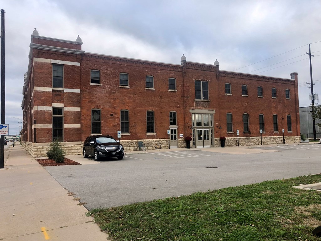A brick building with a black car parked in front.