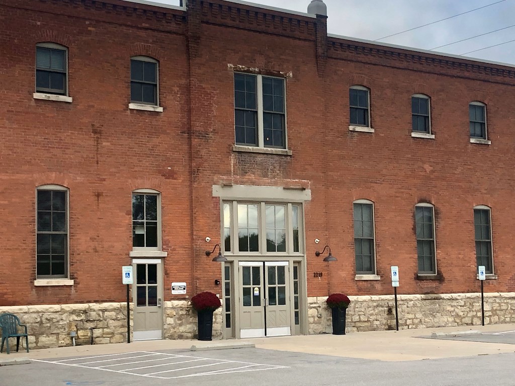 A red brick building with a grey door and windows.