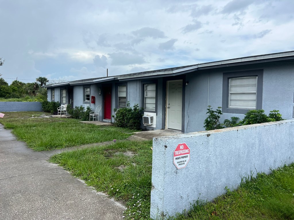 A row of houses with a sign on the wall that says "For Sale".