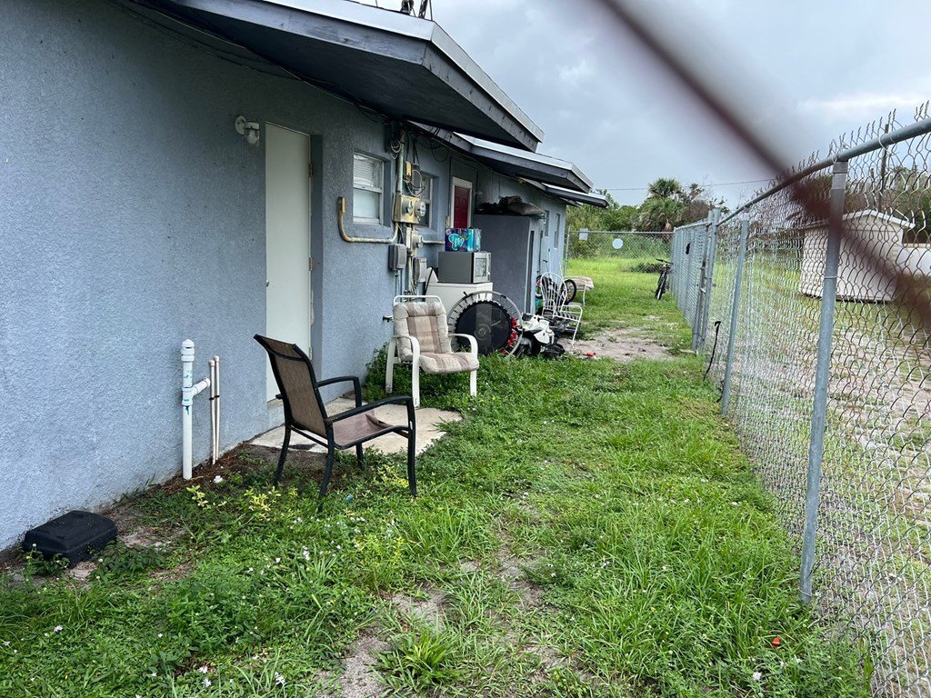 A chair is placed on the grass in front of a house.