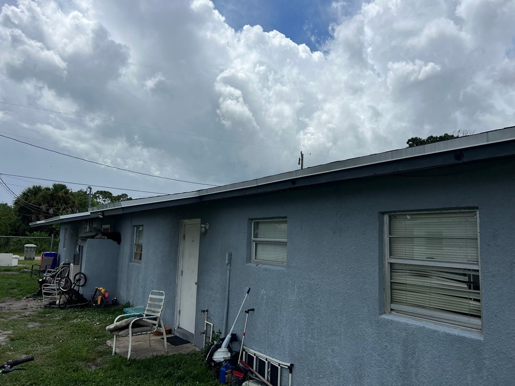 A blue house with a white door and a chair outside.