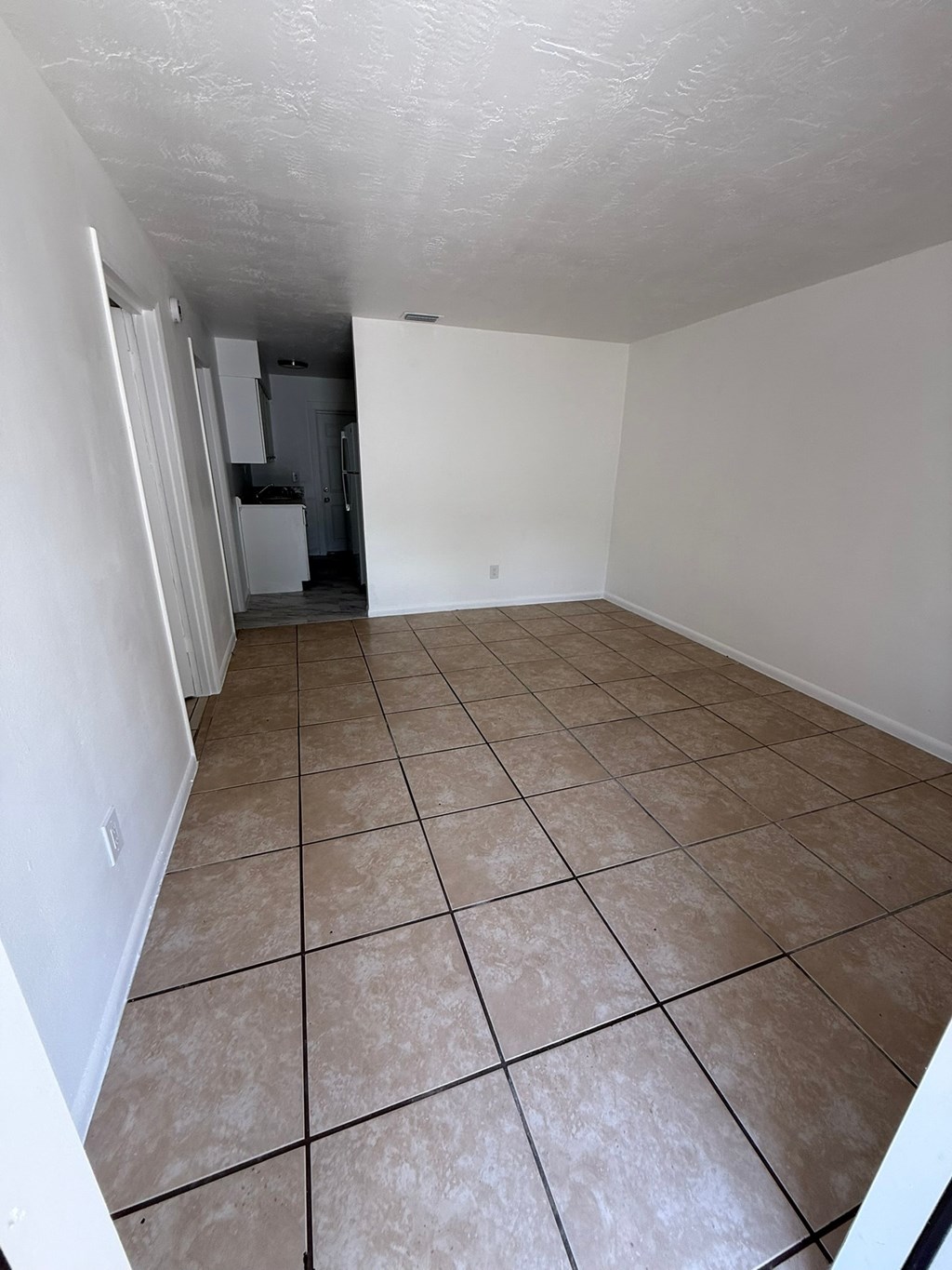 A room with white walls and tiled flooring.