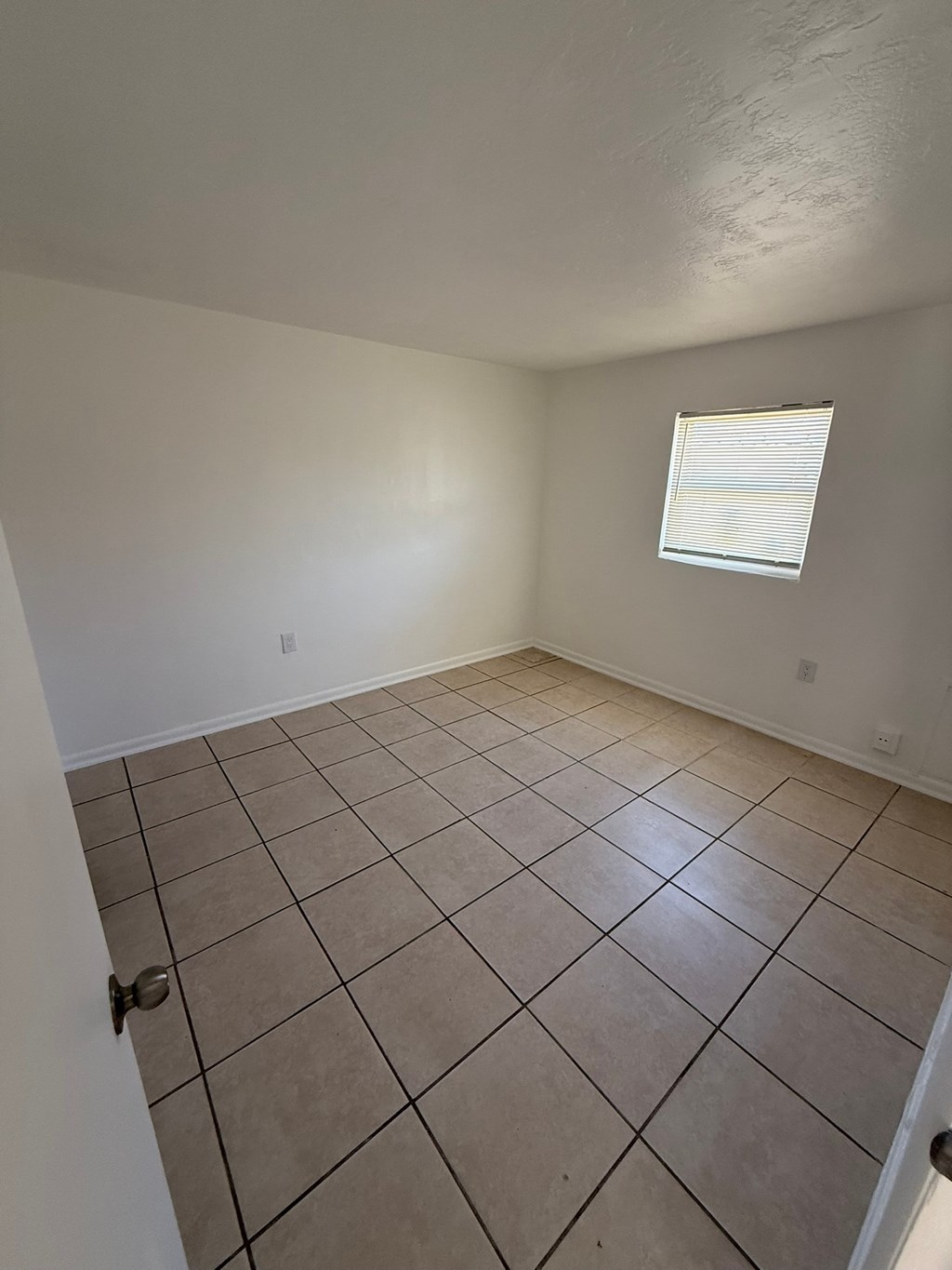 A room with a tiled floor and a window.