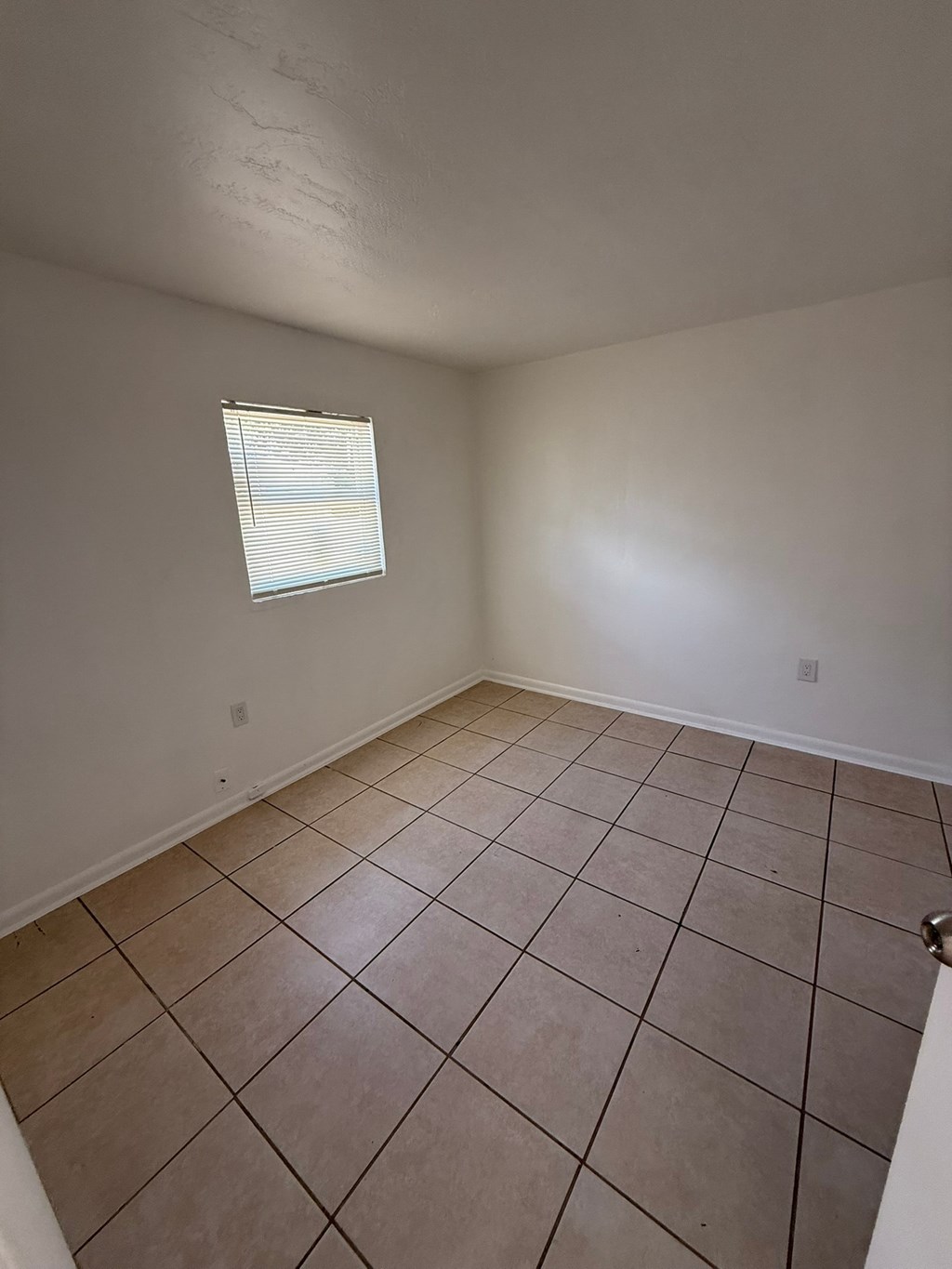 A room with a tiled floor and a window.