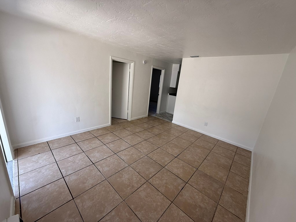 Empty room with tile flooring and white walls.