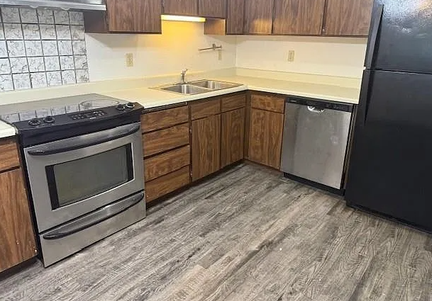 A kitchen with a black refrigerator, stove, and oven.