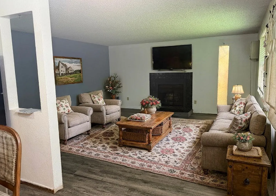 A living room with a fireplace and a painting on the wall.