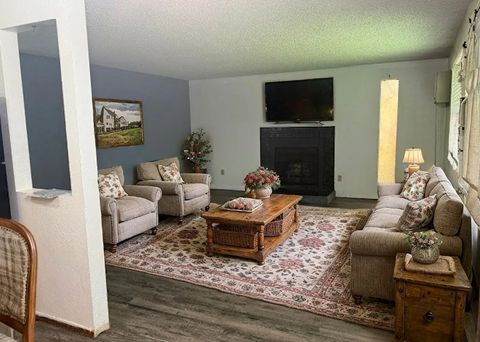 A living room with a fireplace and a painting on the wall.