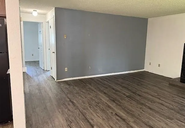 A room with a grey wall and wooden flooring.